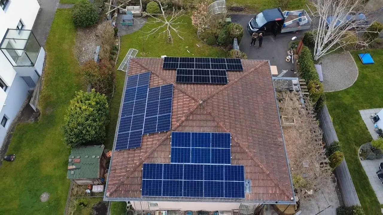 Einfamilienhaus, Montage einer Photovoltaikanlage im Gange, Team mit Hebebühne