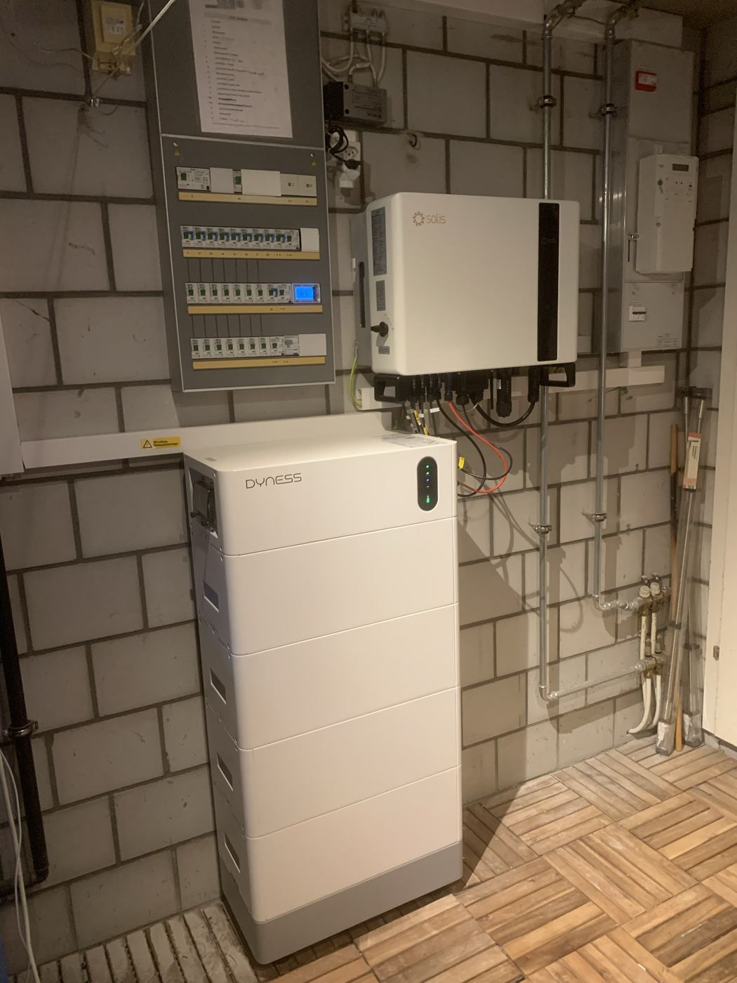 Technikraum im Keller mit Wechselrichter, Verteilerkasten und gestapeltem Batteriespeicher